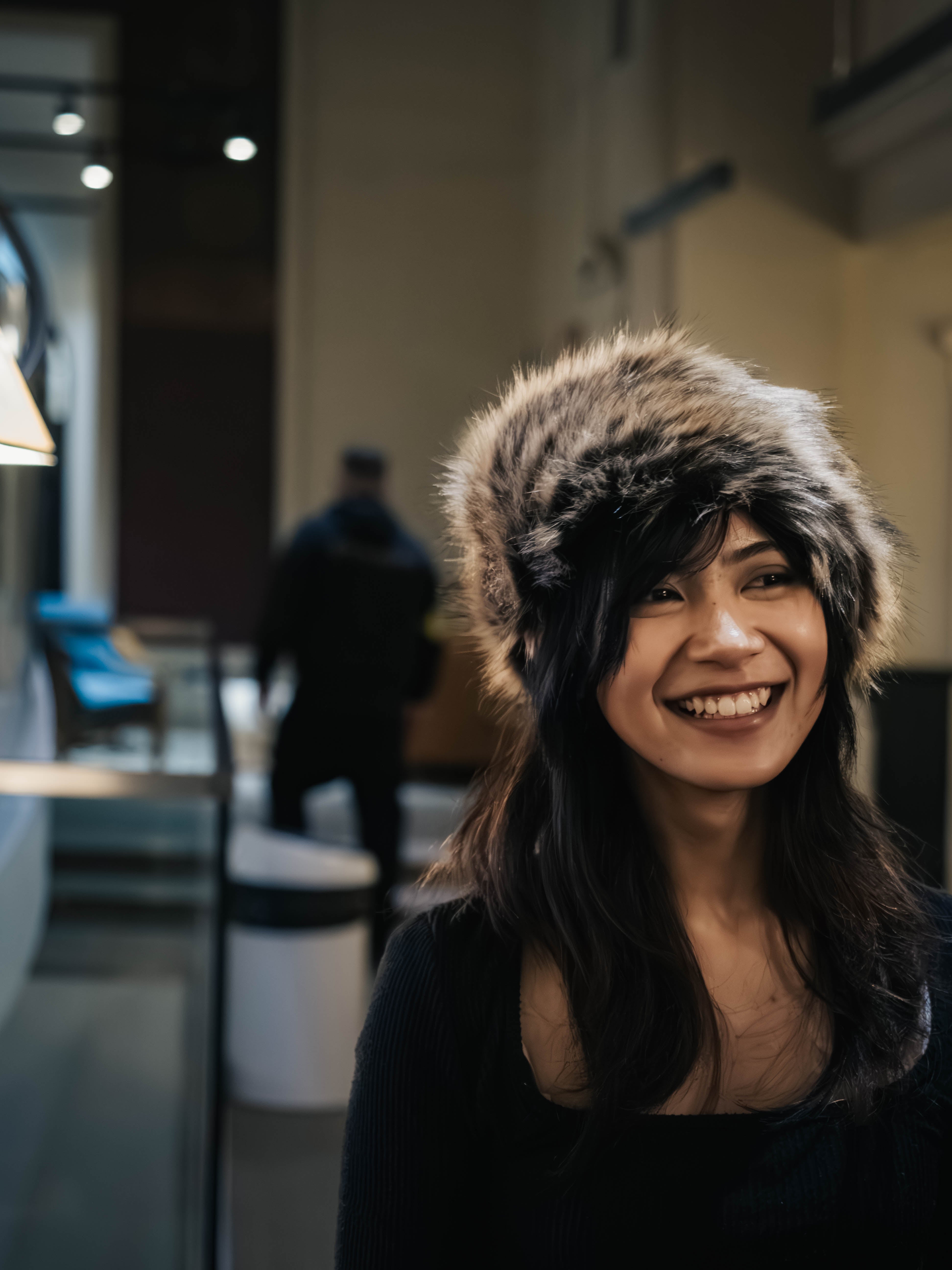 Person wearing a fur hat in an indoor setting
